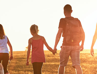 family holding hands walking with sun setting