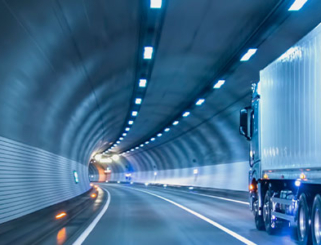 semi tractor trailer alone in lighted tunnel