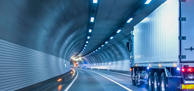 semi tractor trailer alone in lighted tunnel